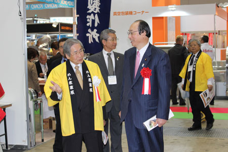 (社)日本麺類業団体連合会の鵜飼良平会長(左)の案内で会場を回る